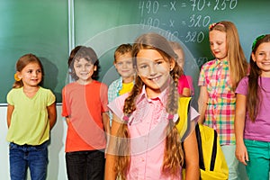 Beautiful girl wears yellow rucksack with pupils photo