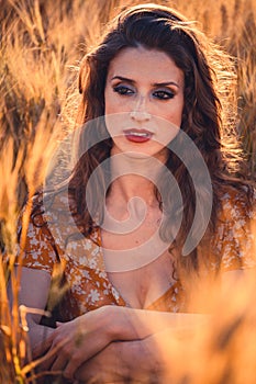 Beautiful girl in a wheat field. Natural sunlight during sunset