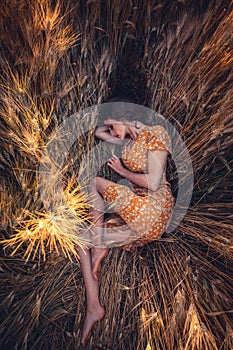 Beautiful girl in a wheat field. Natural sunlight during sunset