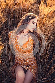 Beautiful girl in a wheat field. Natural sunlight during sunset