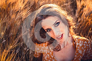 Beautiful girl in a wheat field. Natural sunlight during sunset