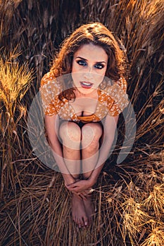 Beautiful girl in a wheat field. Natural sunlight during sunset