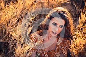 Beautiful girl in a wheat field. Natural sunlight during sunset