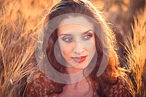 Beautiful girl in a wheat field. Natural sunlight during sunset