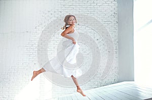 Beautiful girl in white dress flying