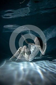 Beautiful Girl in White Dress Underwater. Water Magic. Underwater Photography. Art