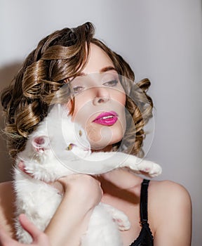 Beautiful girl with a white fluffy cat in her arms.