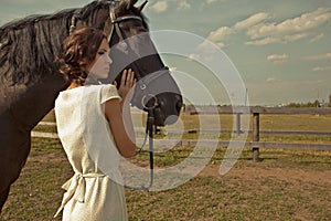 Beautiful girl in a white gown with horse