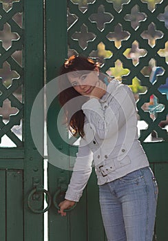 Beautiful girl in in white jacket near the wooden gate