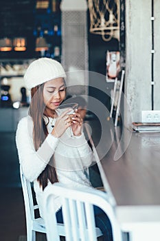 Beautiful girl in white outfit drinking Martini in a bar