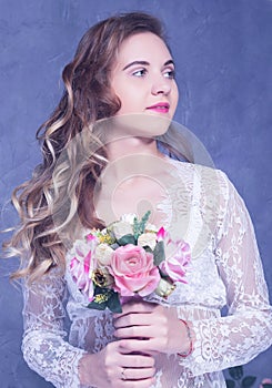 Beautiful Girl in a white peignoir with a bouquet of flowers