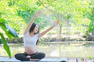 beautiful girl who is 8 months pregnant is doing yoga naturally