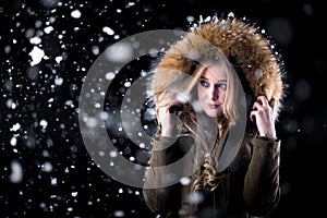 Beautiful girl in winter jacket in snow