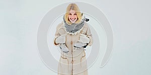 Beautiful girl in the winter outdoors. Beautiful happy laughing young woman wearing winter hat gloves and scarf. Winter