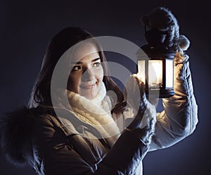 Beautiful girl on winter snow with Christmas lantern