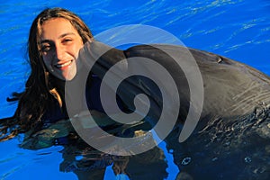 Beautiful girl woman kissing a gorgeous dolphin flipper smiling face happy kid swim bottle nose dolphins