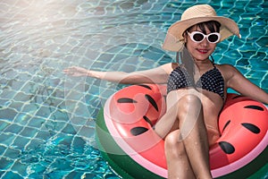 Beautiful girl Woman relaxing on watermelon lilo in pool