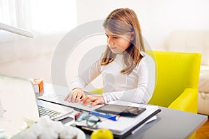 Beautiful girl working on her school project at home