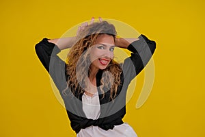 beautiful girl on a yellow background. Pretty brave woman showing wild devilish side making bull horns with her fingers on her