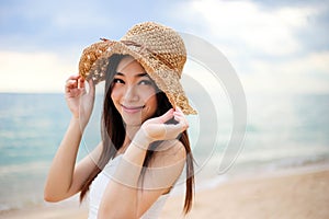 Beautiful girl young woman asia in a  hat smiling on the beach at sunset,enjoy summer vacation on the beach