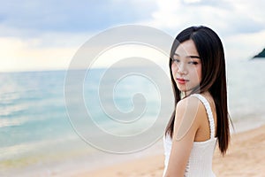 Beautiful girl young woman asia standing in water on sandy on the beach at sunset feeling sad