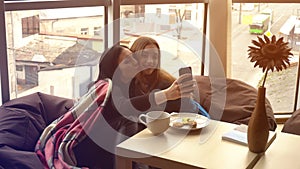 Beautiful girlfriends talking and taking pictures on the phone