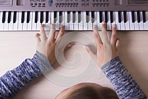 Beautiful girls hands playing electronic piano keyboards.