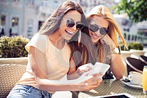 Beautiful girls having fun smiling together in a cafe outdoor