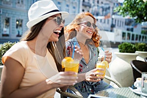 Beautiful girls having fun smiling together in a cafe outdoor