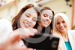 Beautiful girls taking picture in cafe in city