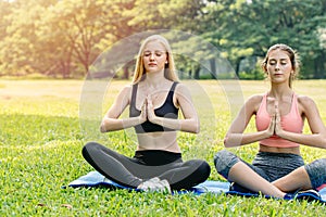 Beautiful girls teen friend do yoga for healthy in green park holiday sitting hand lotus eyes closed concentration posture