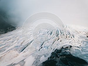 Beautiful glaciers flow through the mountains in Iceland. Aerial view and top view.