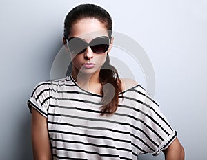 Beautiful glamour woman posing in fashion sunglasses on blue background