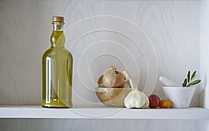 Beautiful glass bottle of healthy organic cooking oil, which can also be olive oil, on a white wall shelf in a Mediterranean style