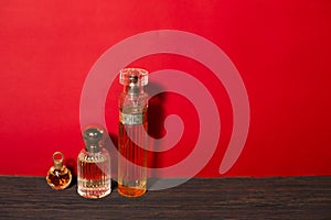 Beautiful glass jars with perfume on a red background