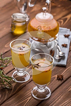 Beautiful glass teapot with orange sea buckthorn tea. Hot winter drinks