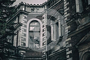 A beautiful and gloomy building of an old abandoned manor house. Old window.