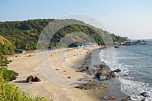 Beautiful Goa beach, sandy coast, rocky stones and sea high view and people at holiday in India, arambol, sweet lake