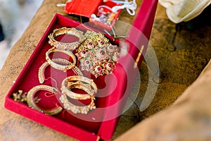 Beautiful golden bracelets and rings on bed. Wedding gold bangles and bracelets.