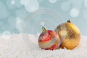 Beautiful golden Christmas balls in the snow on a blue background with bokeh lights. happy new year card