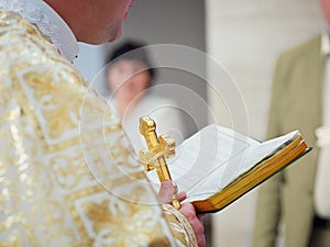 Beautiful golden cross in male hands of priest