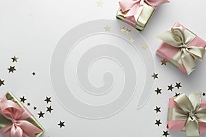 Beautiful golden gifts glitter conffeti pink bows ribbon on white. Christmas, party, birthday background. Celebrate shinny