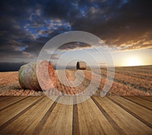 Beautiful golden hour hay bales sunset landscape with wooden planks floor