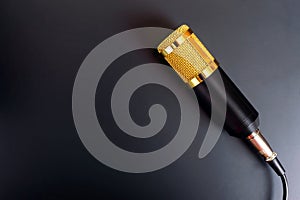 Beautiful golden microphone on a black background, copy space.