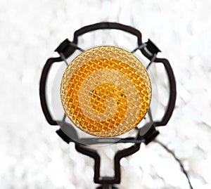 Beautiful golden microphone on a light blurred background
