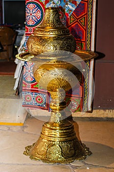 Beautiful golden oriental decorative table with amazing pattern and red carpet on background. Closeup, Egypt.