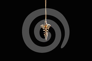 Beautiful golden pendulum with chain on black background. Hypnosis session