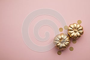 Beautiful golden pumpkins on pastel pink. Flat lay thanksgiving composition