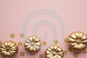 Beautiful golden pumpkins on pastel pink. Flat lay thanksgiving composition