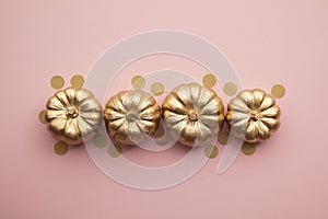 Beautiful golden pumpkins on pastel pink. Flat lay thanksgiving composition